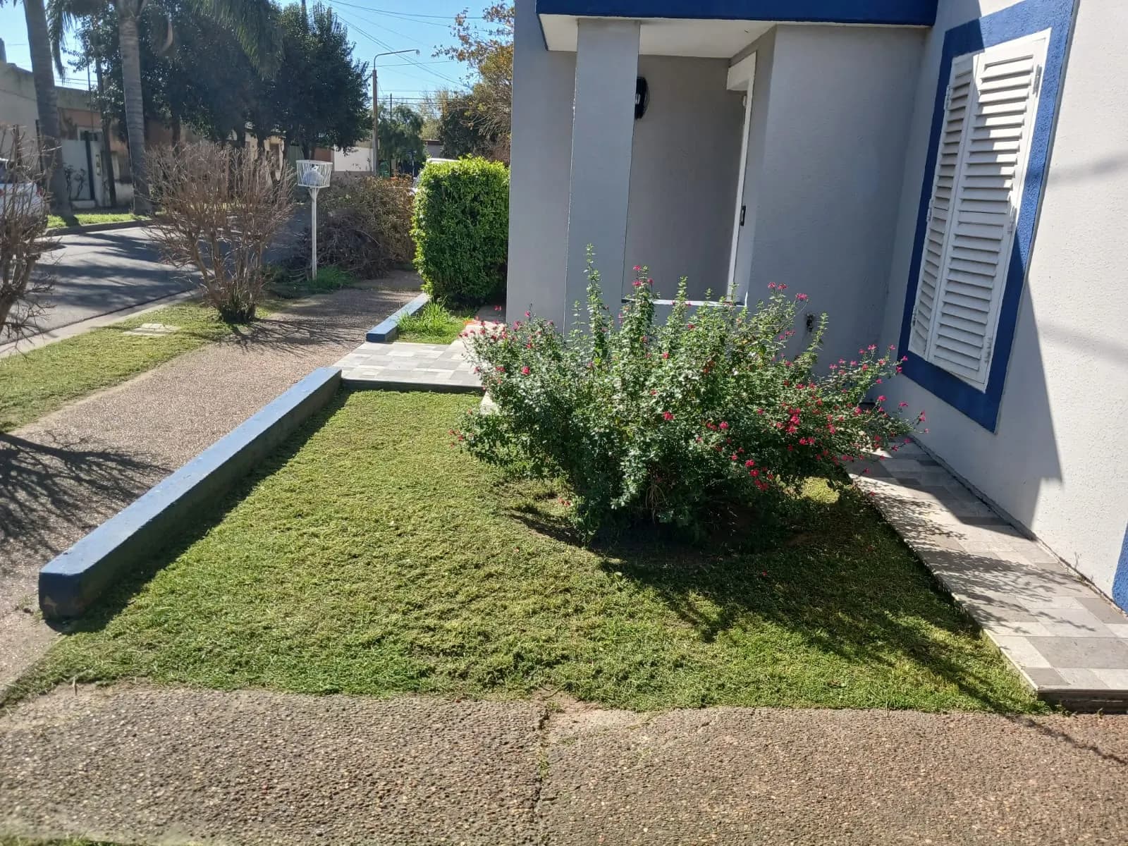 Frente de casa con césped recién cortado y canteros prolijos en Bell Ville